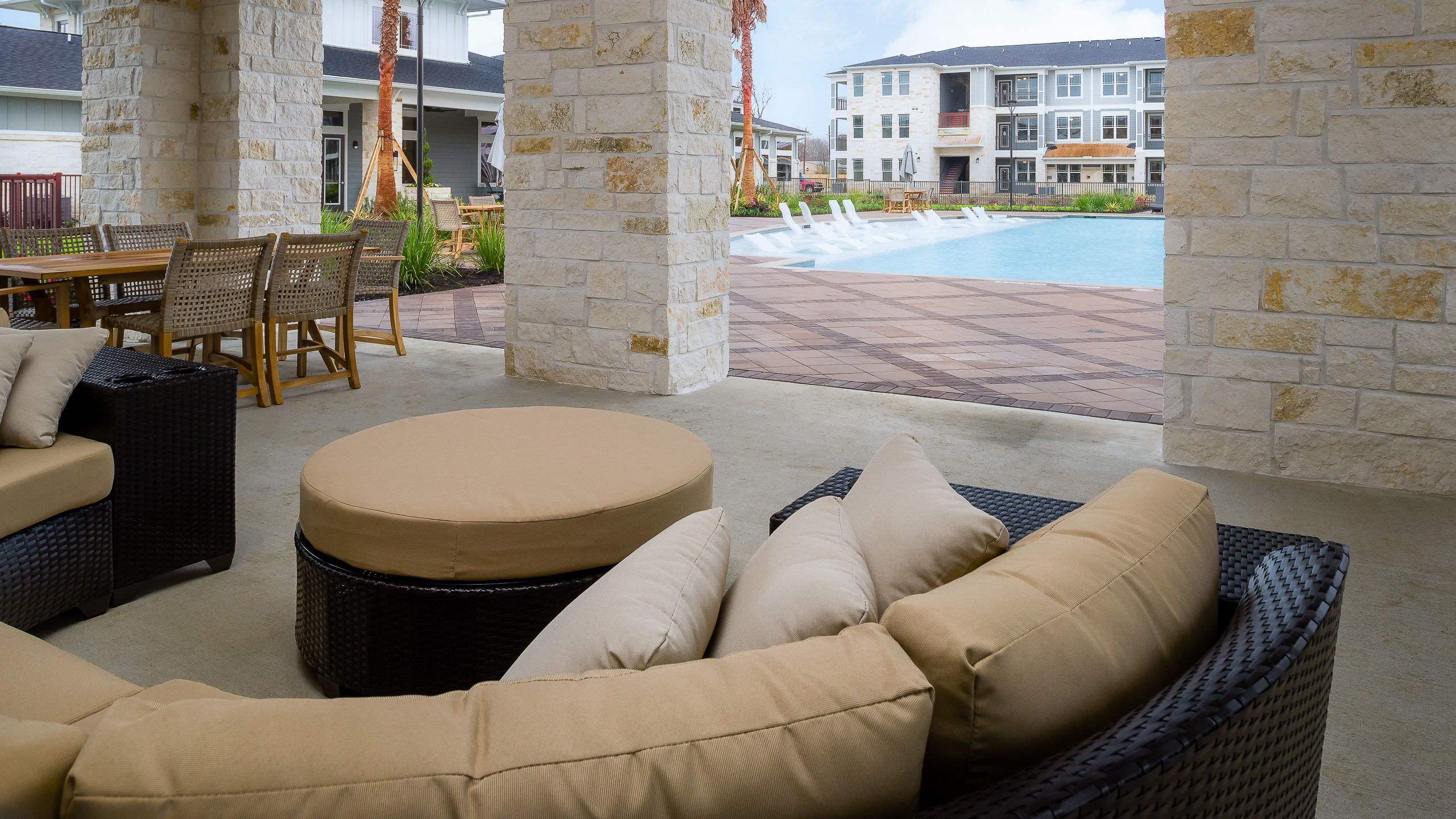 Architectural photo of a covered lounge area by the pool at a modern apartment complex in Baytown, TX.
