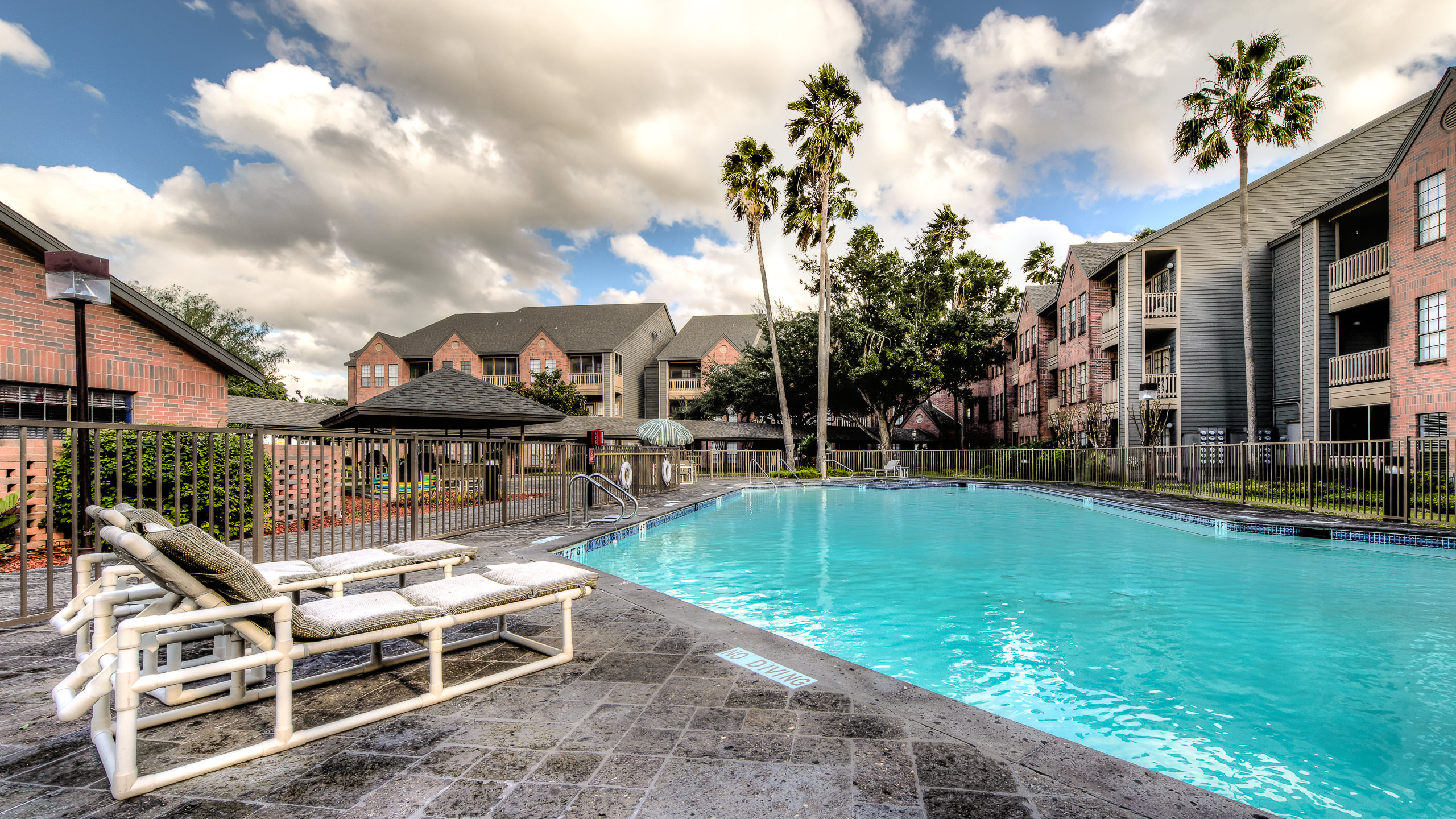 Outdoor architectural photo of a resort-style swimming pool area at a modern apartment complex in McAllen TX