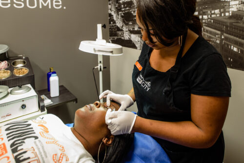 Business branding image of employees with a client in a waxing studio. 