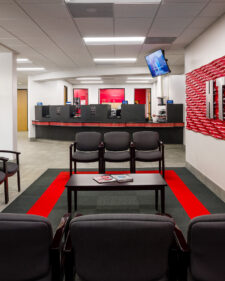 Architectural interior of the renovated Firefighters Credit Union lobby. Bright red accents highlight the modern institutional design.