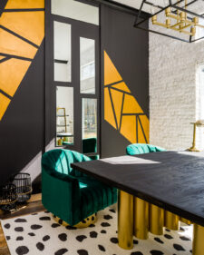 Interior photo of updated study with bold gold and black accents and green chairs