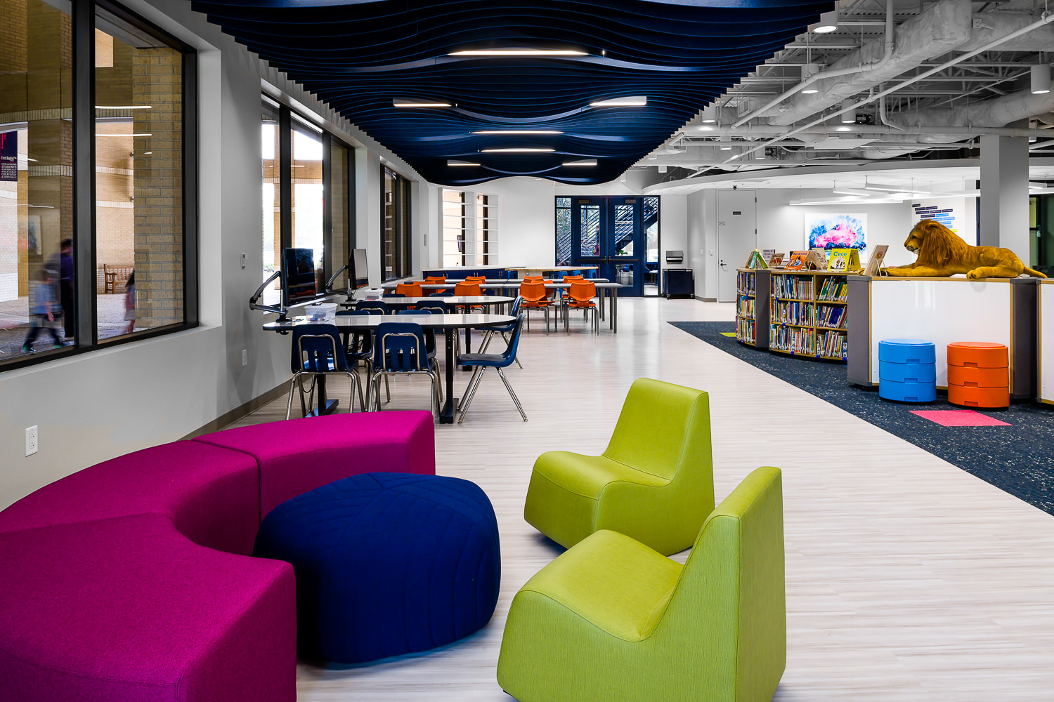 Architectural photo of the First Baptist Church School's new library, highlighting its modern design with bright furnishings and a textured ceiling.