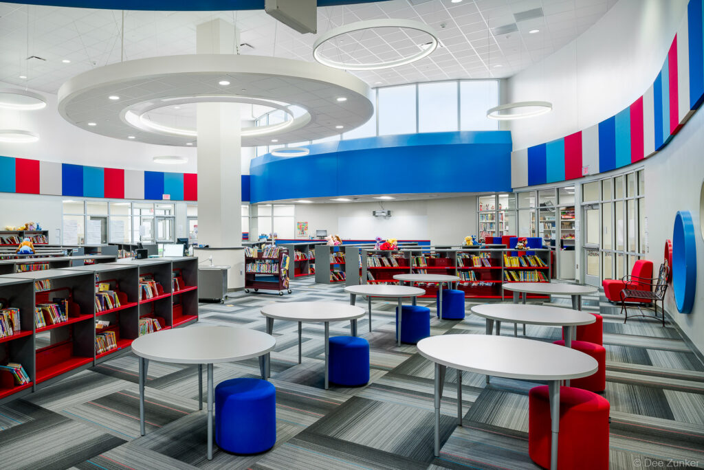 Spacious and bright architectural interior of the Mae Smythe Elementary School library, a modern institutional space in Pasadena, TX.