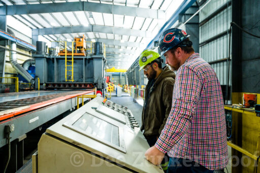 Steel Workers standing at a console in a steel warehouse Houston, TX