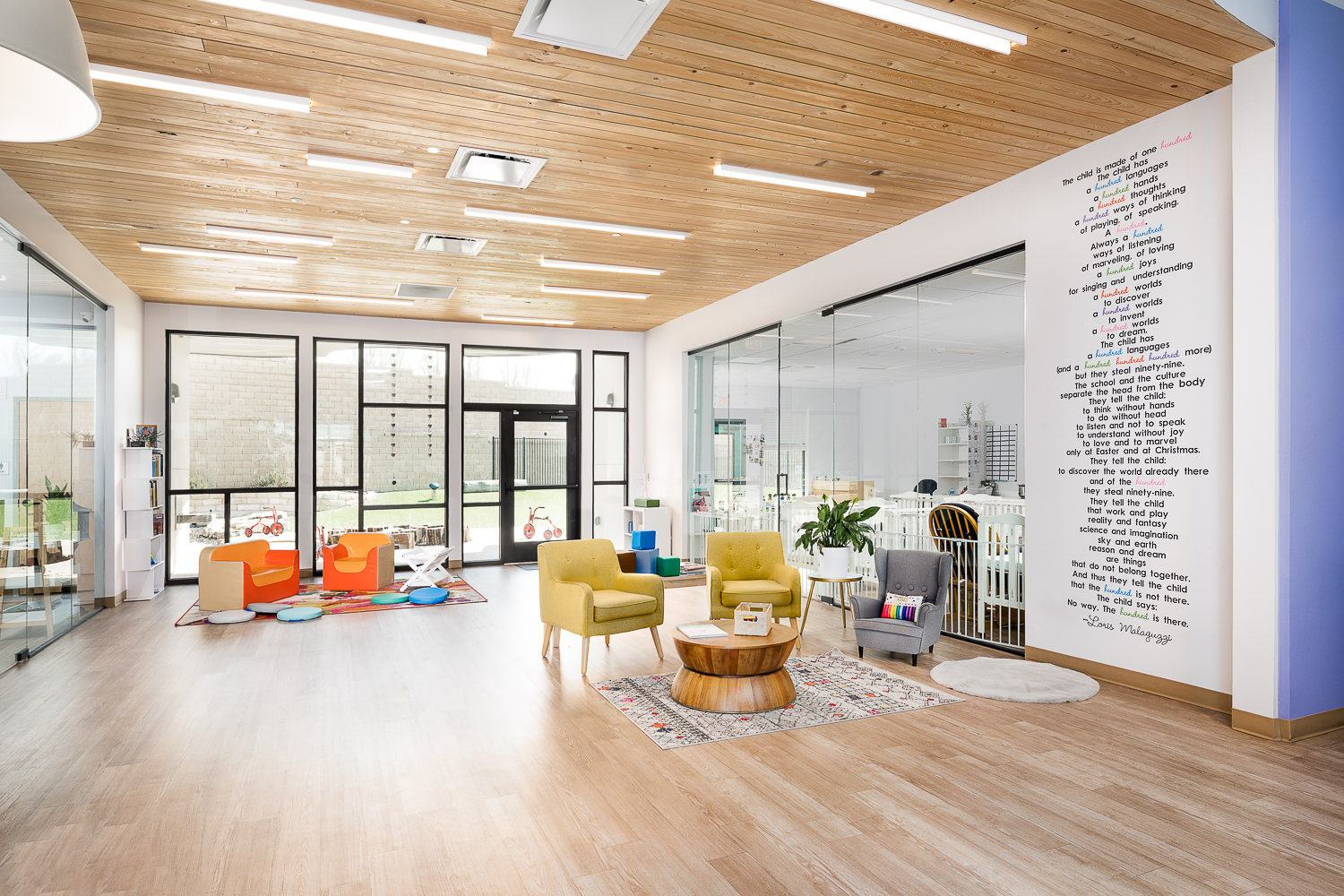Architectural interior of the KLA School in Sweetwater, Austin, TX. The lounge area features a clean design with matching wood floors and ceilings.