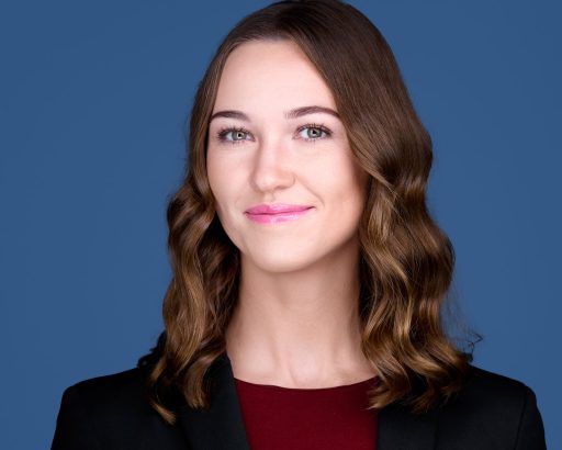 Professional headshot with medium blue background