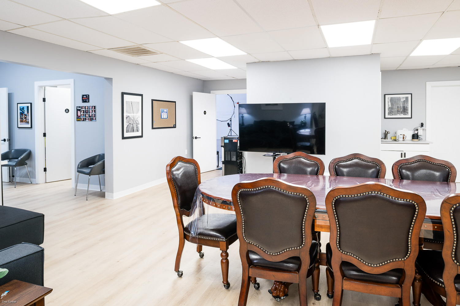 Large client lounge and green room featuring a conference table and TV monitor, perfect for image review or production team meetings. - West Loop Rental Studio