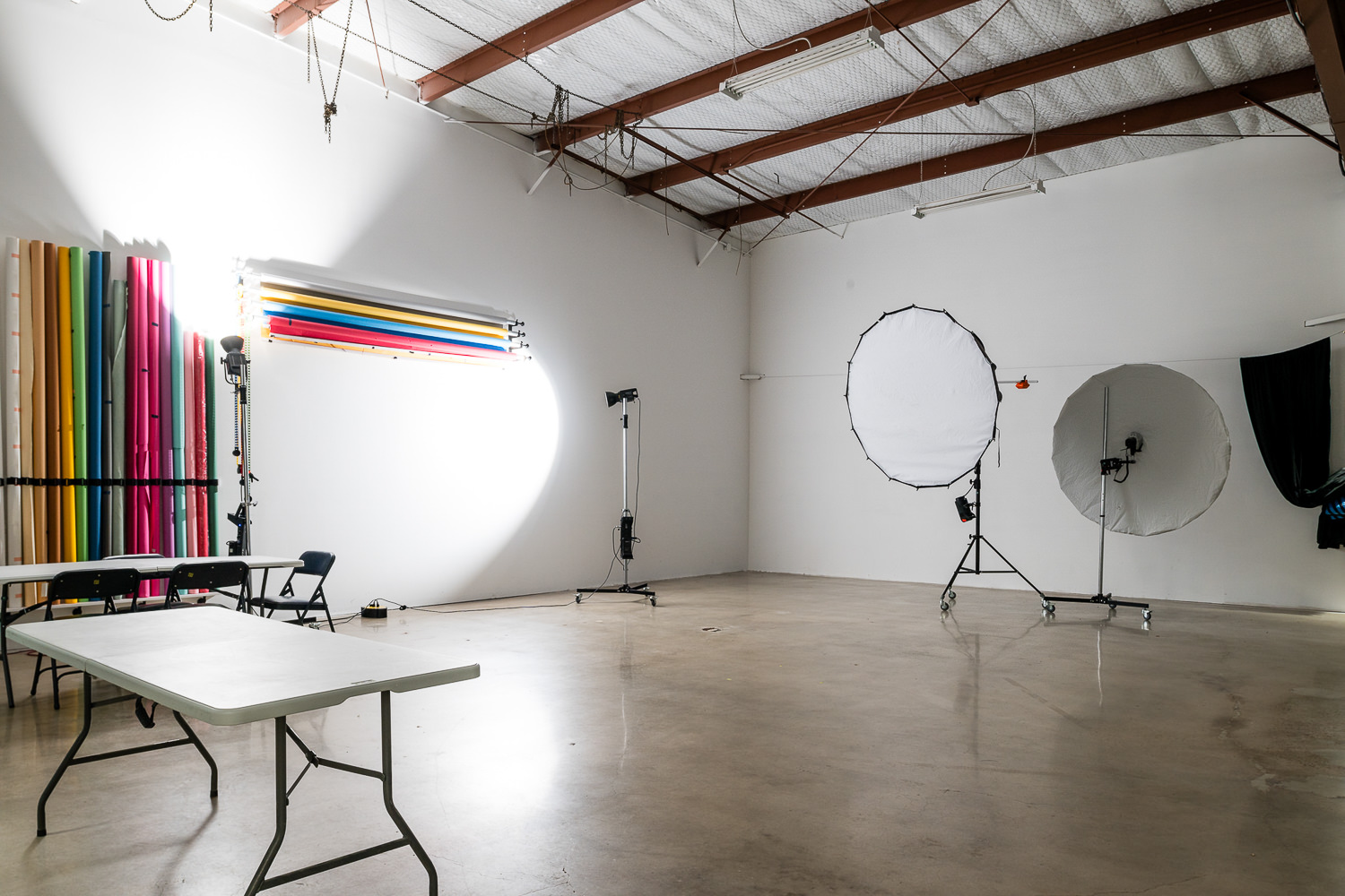 Production rental space setup with large lighting modifiers, C-stands, and background paper ready for a professional headshot session.