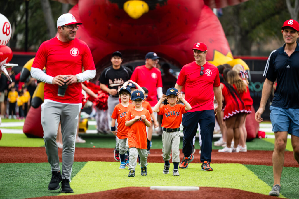 Astros T-Ball players lead the teams into the Opening Day ceremony