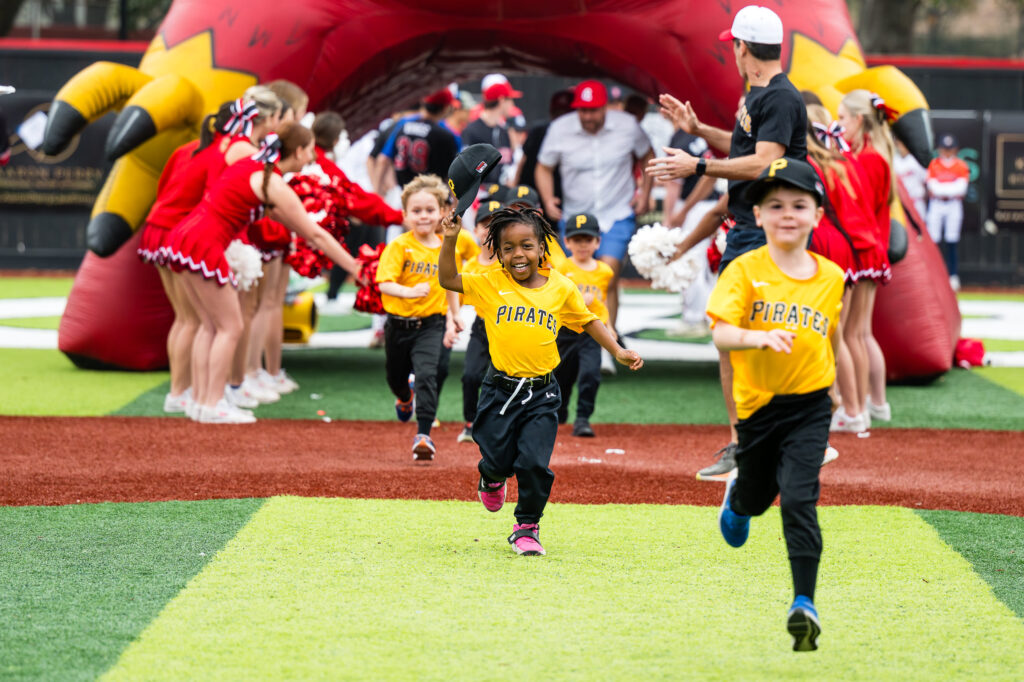 Texas Division Priates run in to the Opening Ceremony during Bellaire Little League