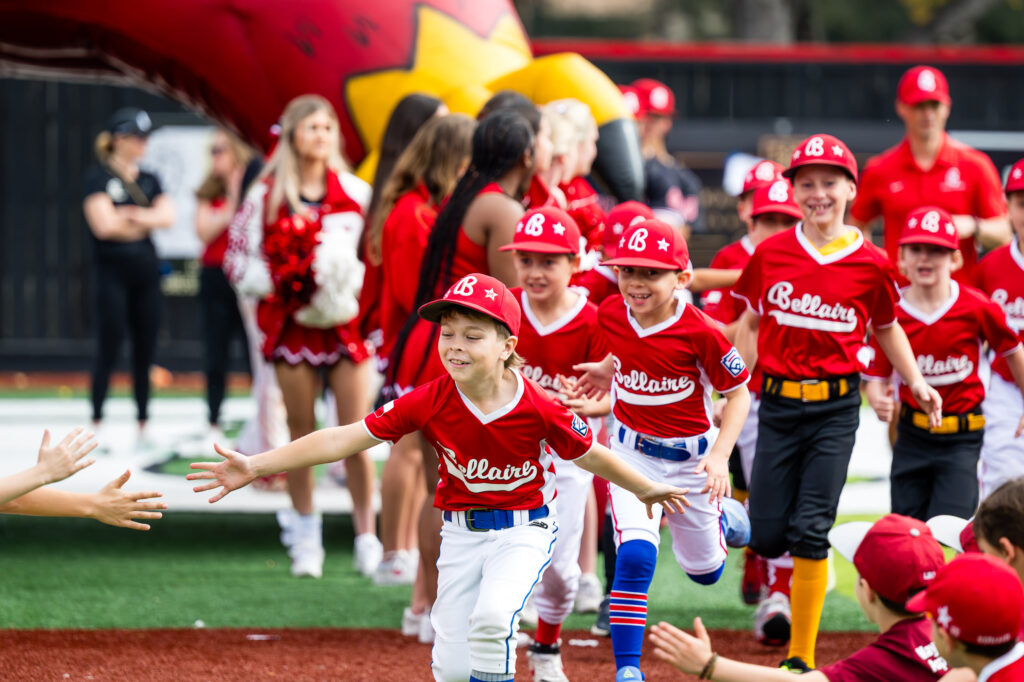 Division team players run in during the opening day ceremony