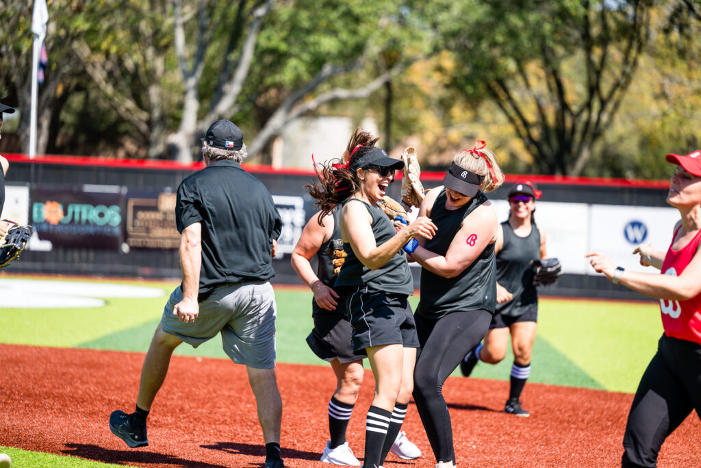 Team mates celebrate each other after making 2 great plays in a row to pull ahead in teh moms sofball game on Bellaire Little League Opening Day 2026