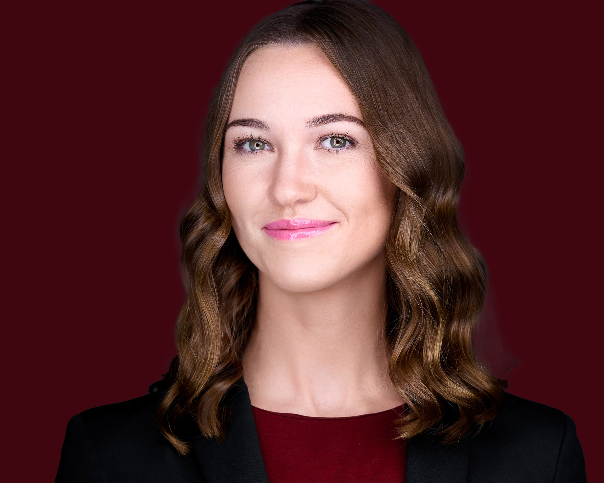 Female professional headshot on maroon background
