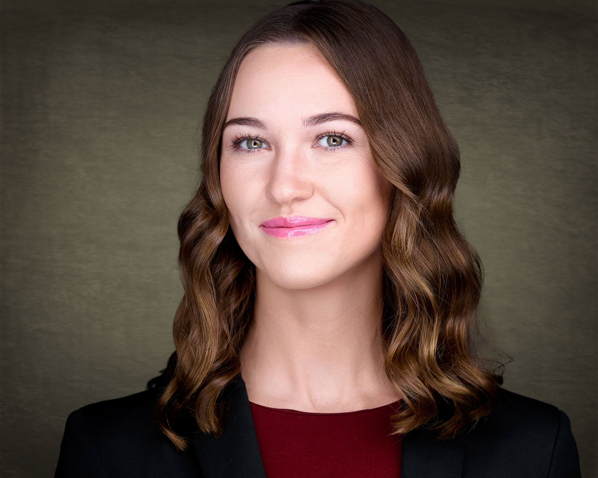 Female professional headshot on warm canvas background