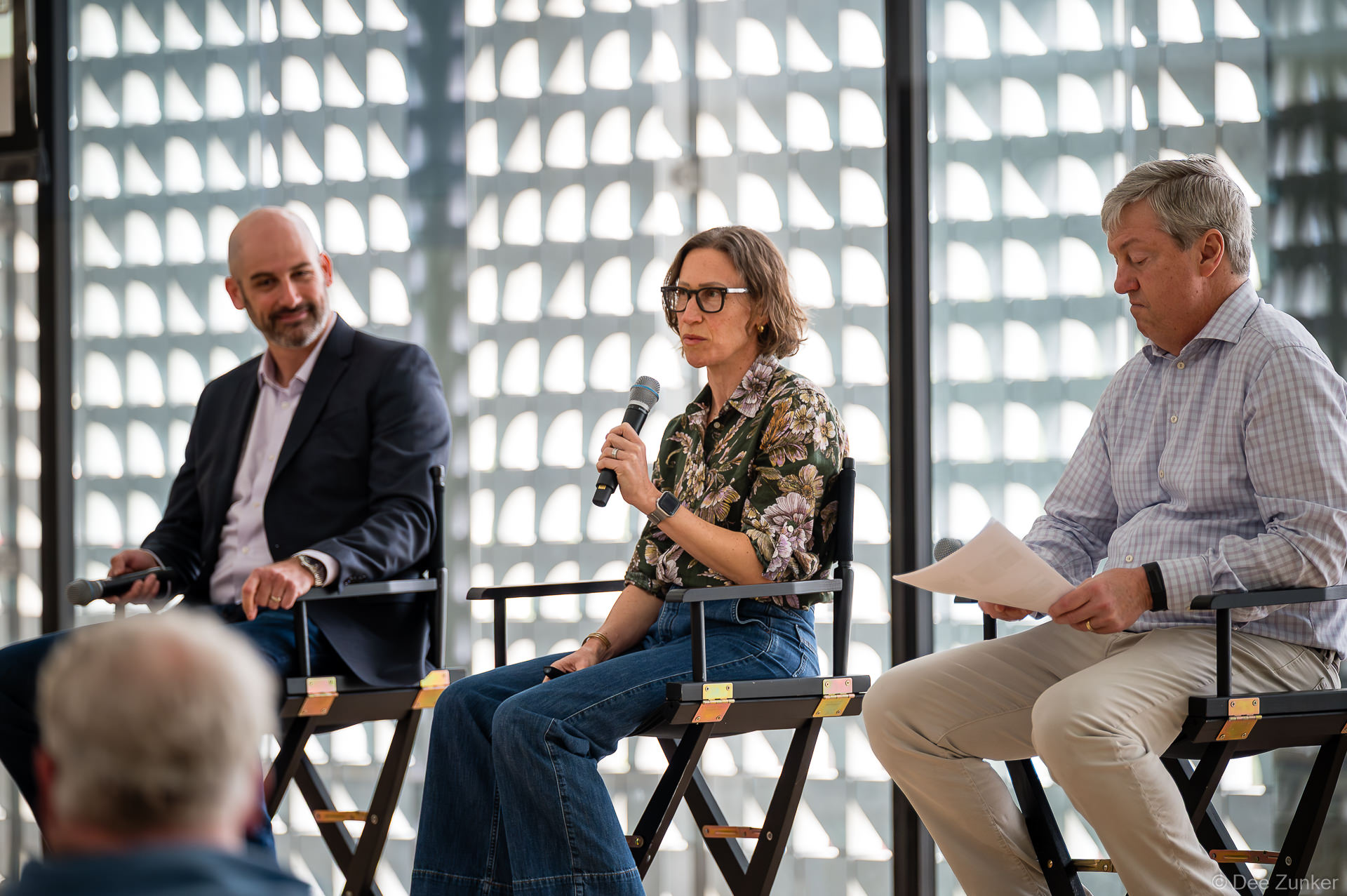 Panelists (Blake Coleman, Catherine Callaway, Bob Stokes) seated in director chairs at Gulf Coast Green 2026 conference, Catherine is speaking into microphone at The Ismaili Center Houston.