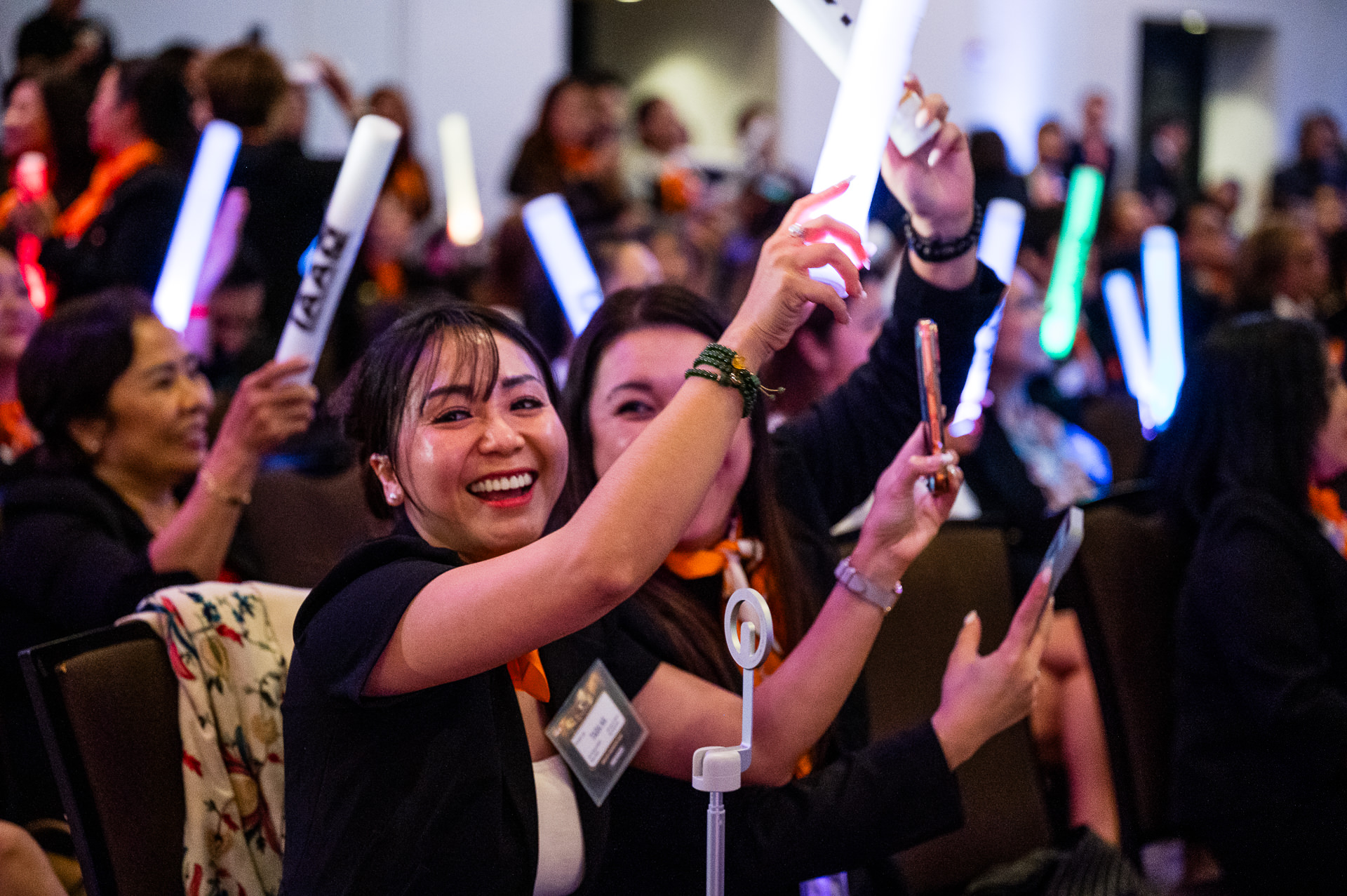 Attendees celebrating at Houston corporate conference with glow sticks