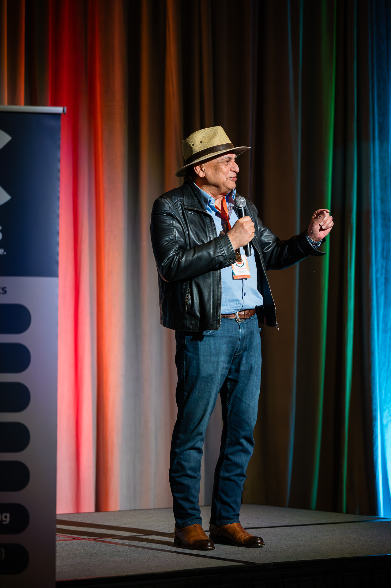 Presenter on stage with microphone at Houston corporate conference
