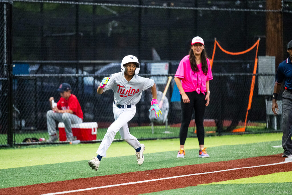 A Twins baserunner sprints around third base during a Bellaire Little League American League game at Weston or Tiras Field in Bellaire, TX.