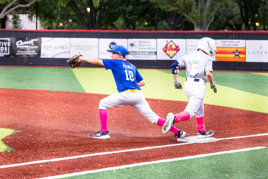 Palmer #10 in blue stretches to catch throw at first base during Bellaire Little League American League game at Weston Field, Bellaire TX.