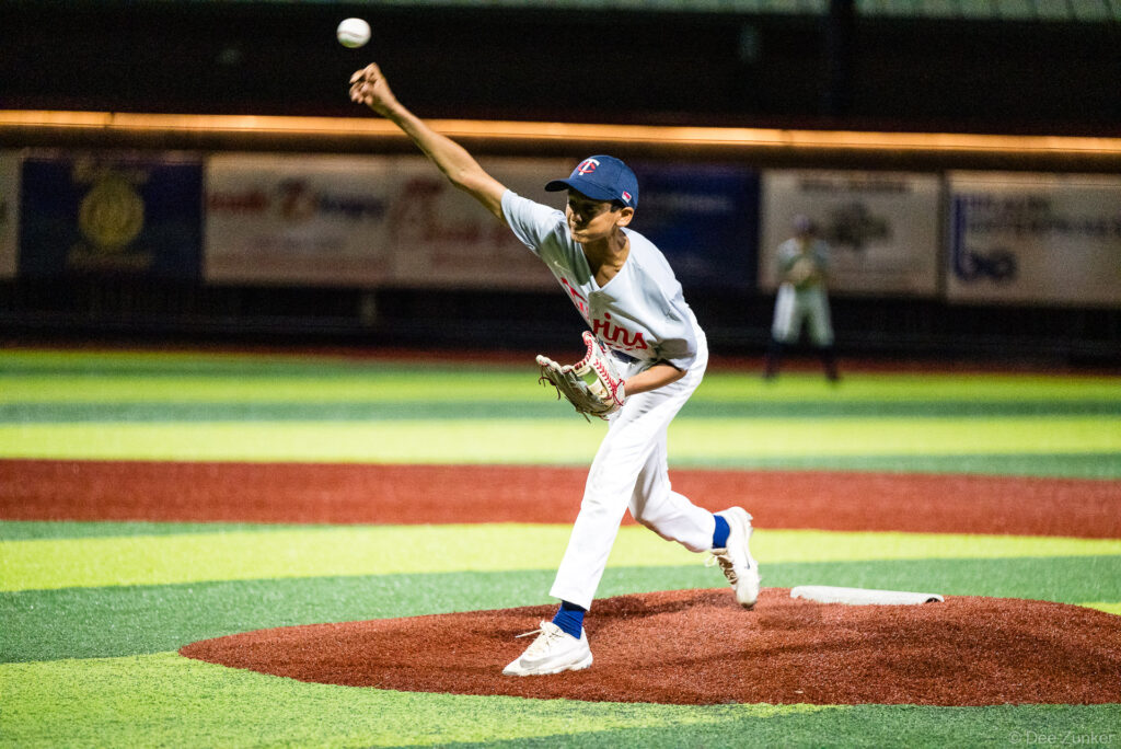 Young Twins pitcher releases a pitch from the mound during a Bellaire Little League American League game at Weston or Tiras Field in Bellaire TX.