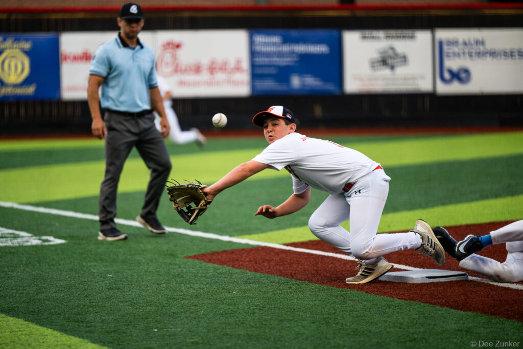 Bellaire Little League Orioles first baseman stretches to catch a throw at first base during an American League game at Weston Field, Bellaire TX.