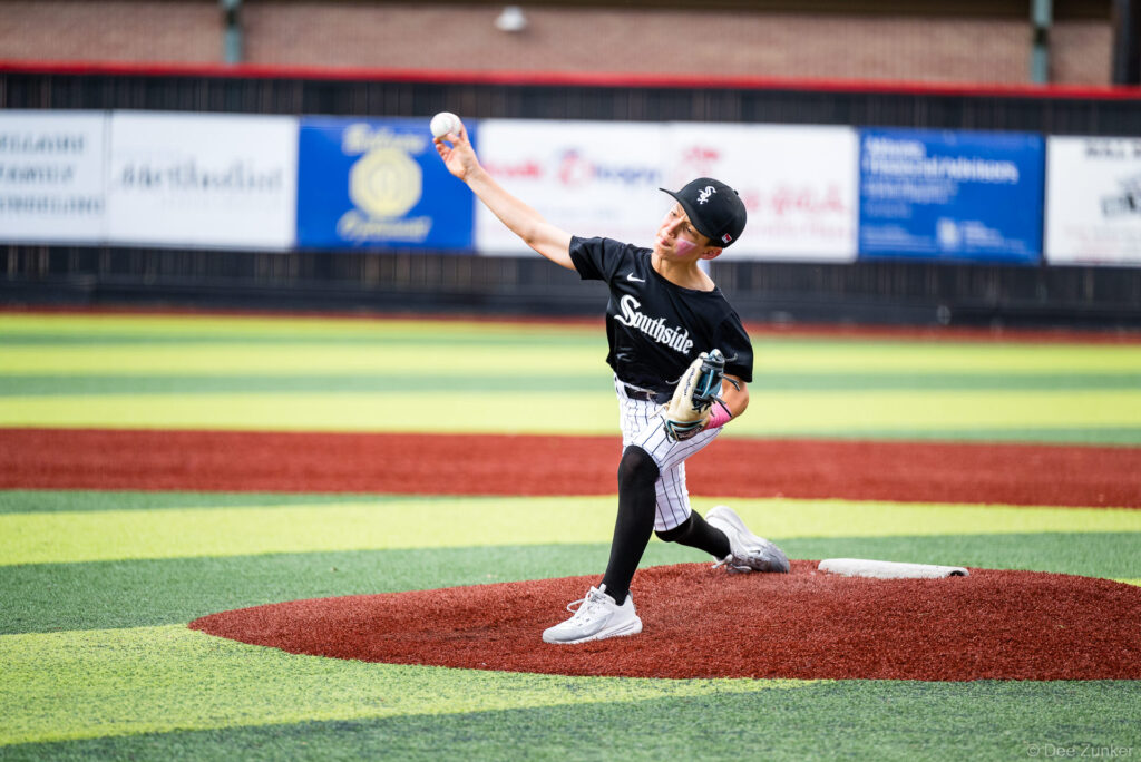 Young White Sox pitcher winds up on the mound during a Bellaire Little League American League game at Weston or Tiras Field in Bellaire TX.
