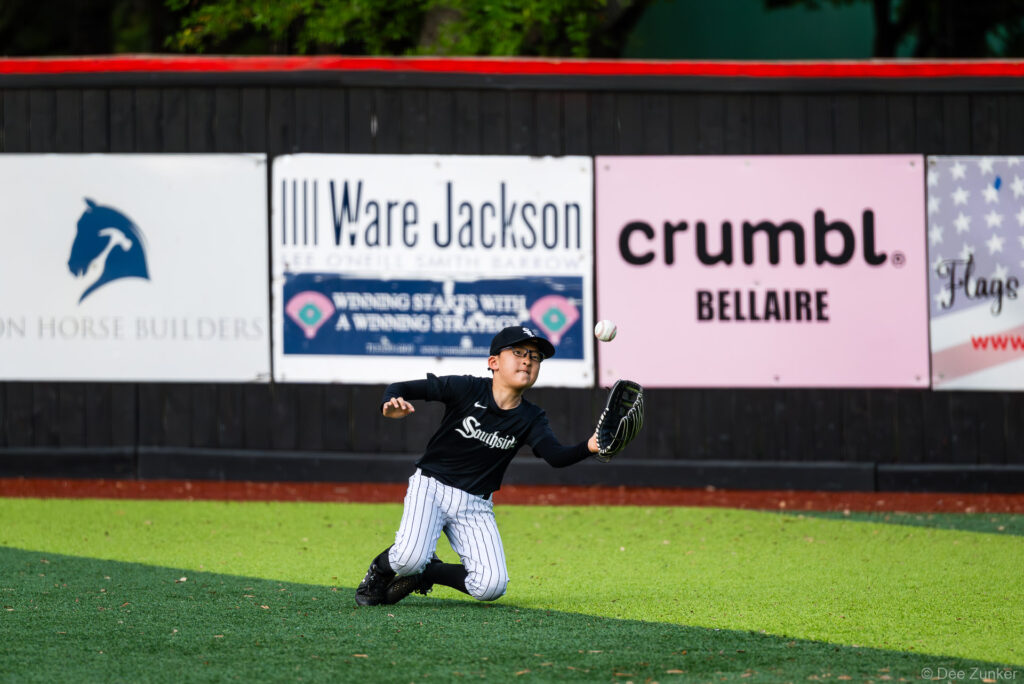 A White Sox outfielder makes a sliding catch attempt in the outfield during a Bellaire Little League American League game at Weston Field.