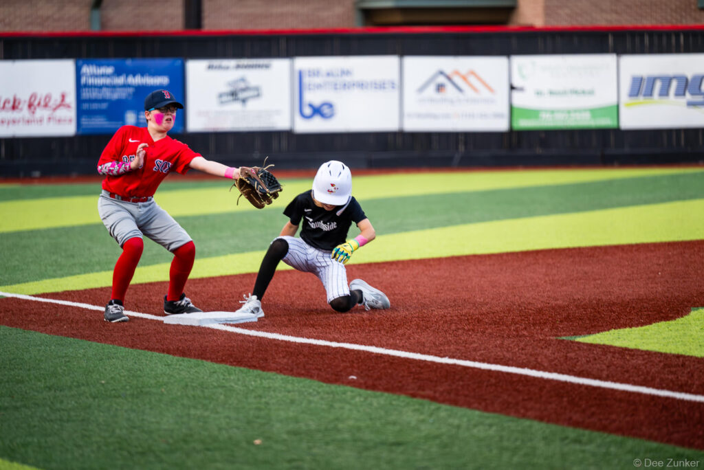 Bellaire Little League Red Sox infielder tags a sliding White Sox baserunner at a base during an American League game at Bellaire TX.