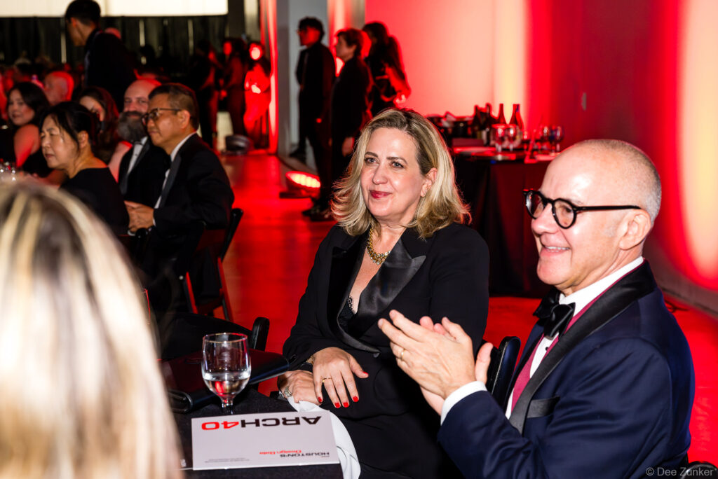 Guests applaud at the 40th Annual AIA Houston Design Gala at The Shop Club Houston, seated at a table with event signage.