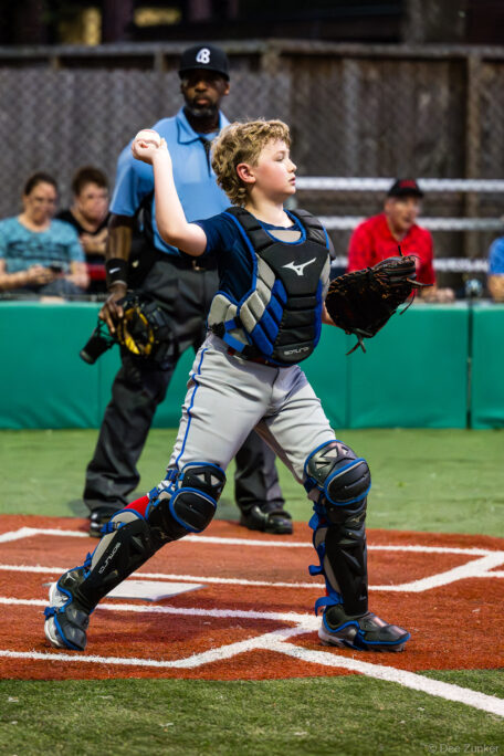 Young catcher in Mizuno gear throws to base during a Bellaire Little League American League game between the Blue Jays and Astros in Bellaire TX.