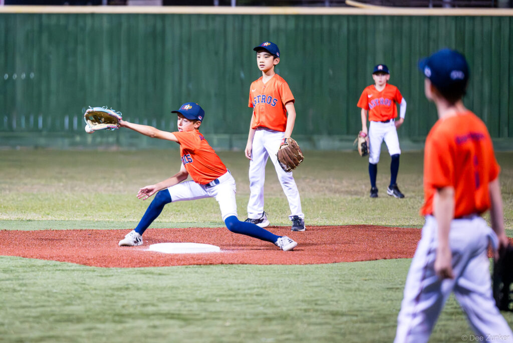 Young Astros pitcher throws from the mound during a Bellaire Little League American League game at Weston or Tiras Field in Bellaire TX.