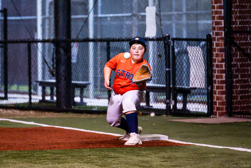 Young Bellaire Little League Astros first baseman stretches to catch a throw at the bag during an American League game at Weston Field.