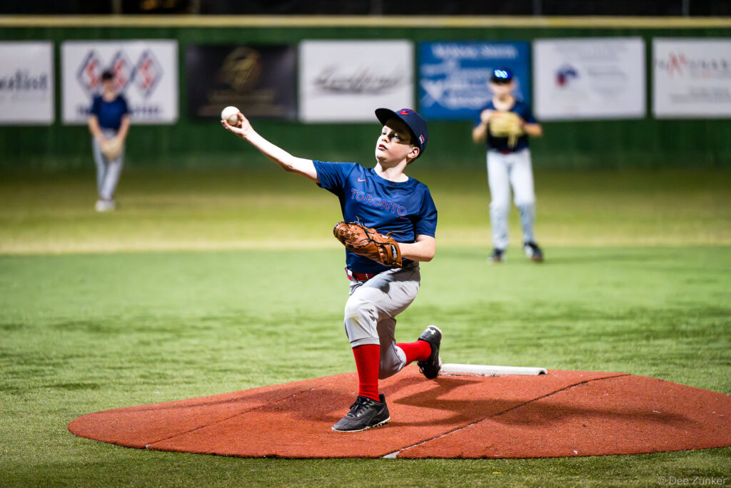 Young Blue Jays pitcher winds up on the mound during a Bellaire Little League American League game at Weston or Tiras Field in Bellaire, TX.