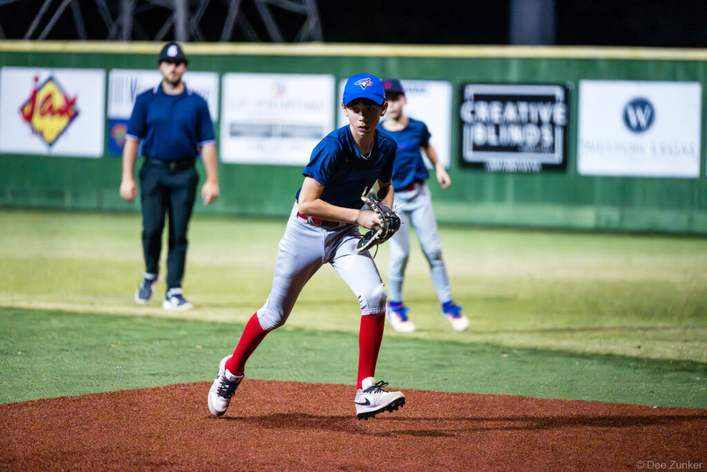 Young Blue Jays pitcher winds up on the mound during a Bellaire Little League American League game at Weston Field in Bellaire TX.