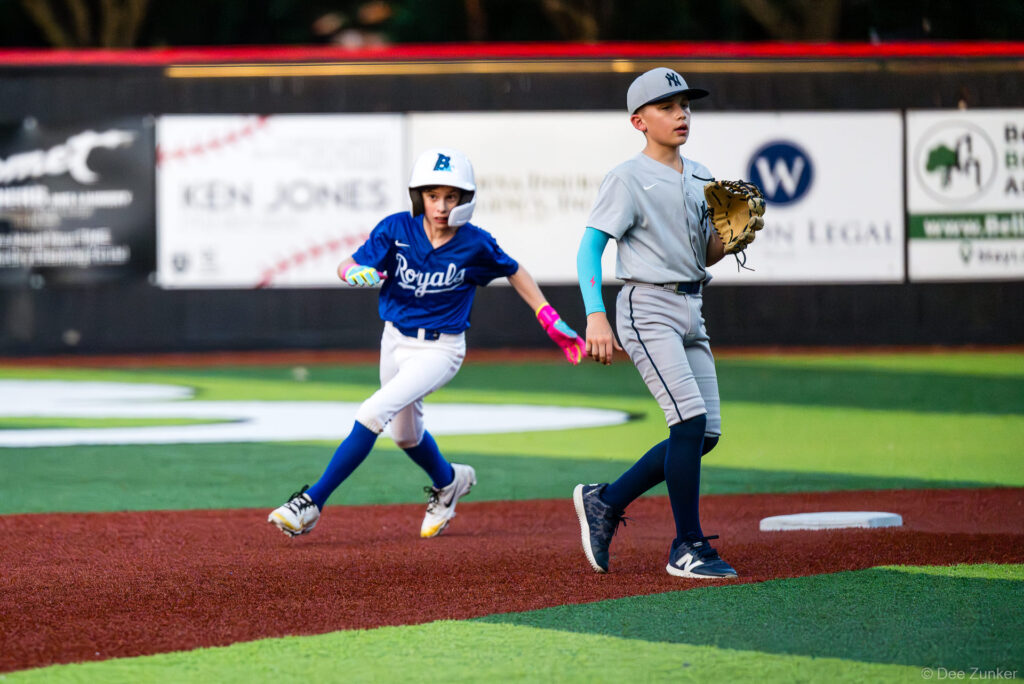 Bellaire Little League Royals baserunner rounds second base past a Yankees fielder during an American League game at Weston Field in Bellaire TX.