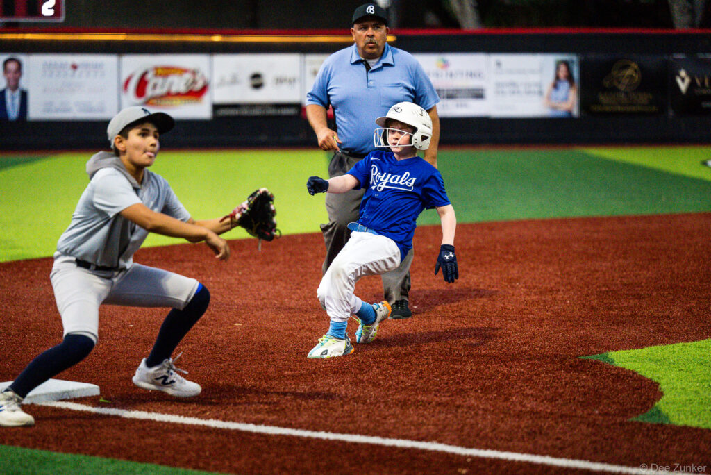 Bellaire Little League Royals baserunner rounds third base as Yankees fielder prepares to catch the throw at Weston Field, Bellaire TX.