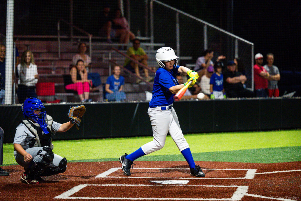 Young Royals batter swings at home plate during a Bellaire Little League American League game against the Yankees in Bellaire TX.