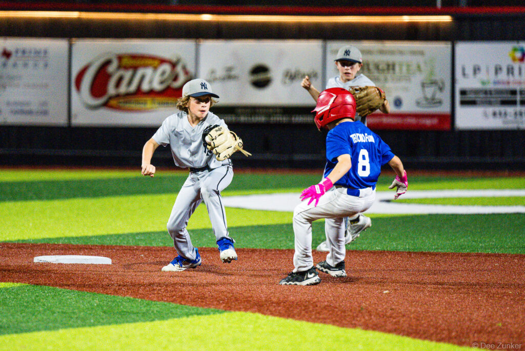 Yankees fielder attempts to tag out Royals runner number 8 in a rundown during Bellaire Little League American League action at Weston Field.