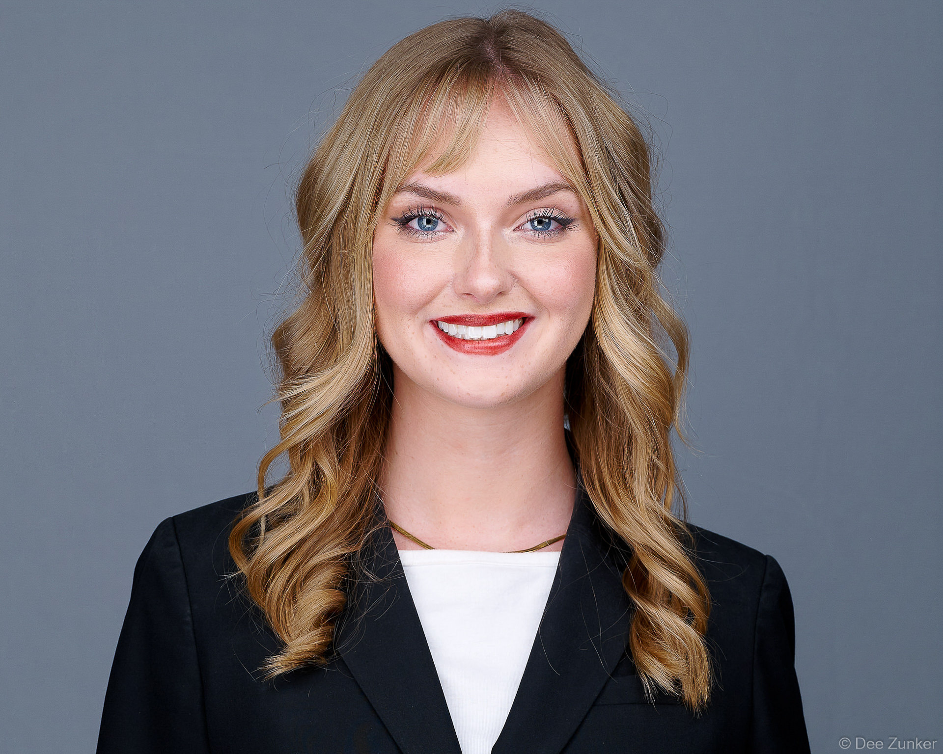 Smiling blonde woman in black blazer, from a Houston conference event headshot booth activation.