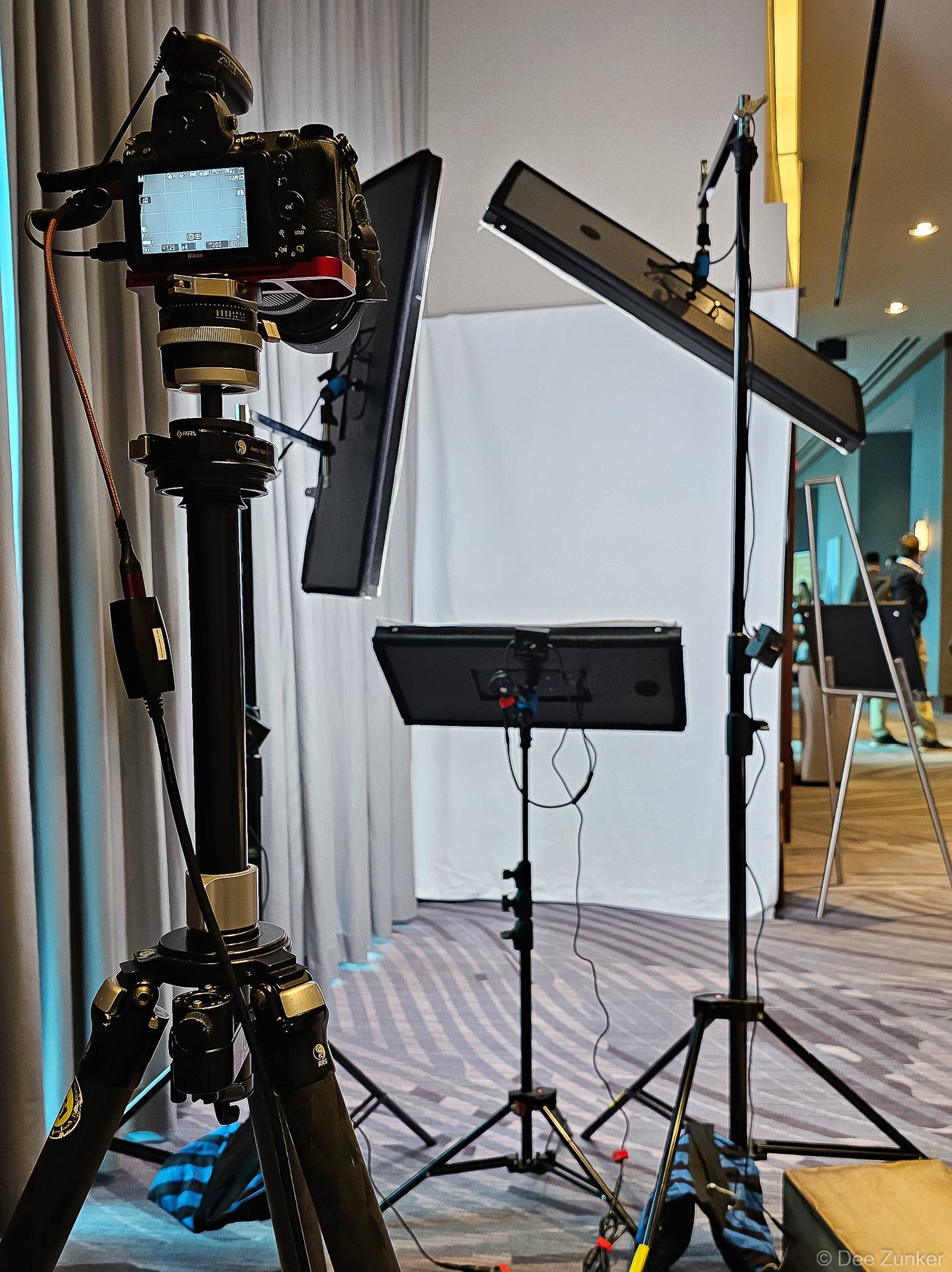 Behind-the-scenes view of a compact event headshot booth setup with camera, lighting, and backdrop at the Westin Houston Memorial City.