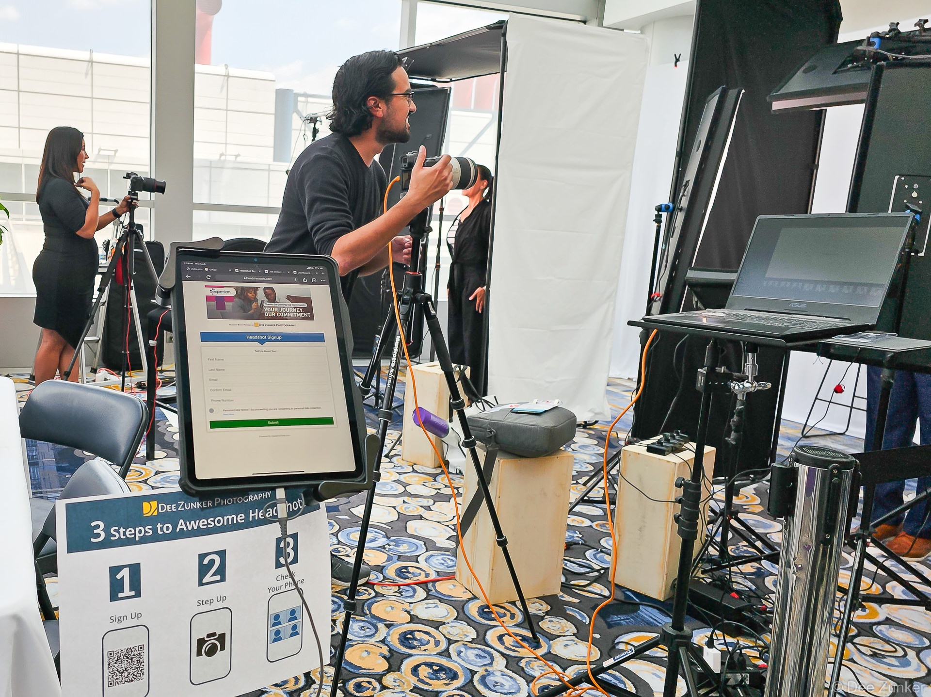 Photographer directing an attendee at a professional headshot booth activation inside the Hilton Americas Houston convention venue