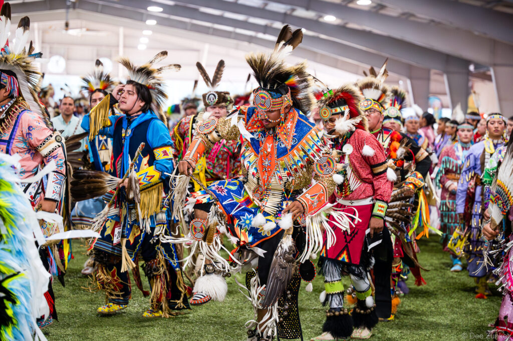 Native American dancers in vibrant regalia and feathered headdresses during the Grand Entry at the Alabama-Coushatta 56th Annual Powwow, Texas.