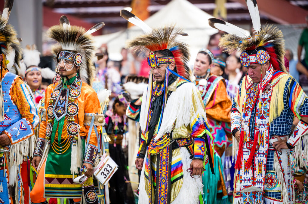 Native American men in elaborate regalia and feathered headdresses during Grand Entry at Alabama-Coushatta 56th Annual Powwow, Texas