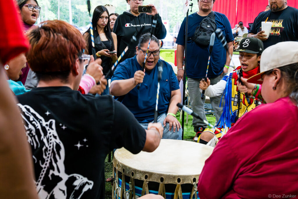 Drum circle performers singing and playing a traditional powwow drum at the Alabama-Coushatta 56th Annual Powwow in Texas.