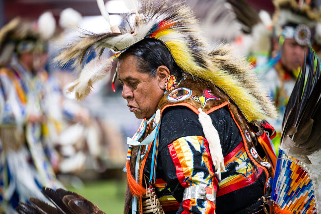 Native American male dancer in full regalia with feathered headdress performing at the Alabama-Coushatta 56th Annual Powwow in Texas
