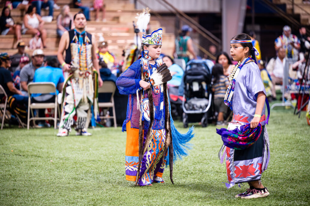 Two children in colorful regalia dance at the Alabama-Coushatta 56th Annual Powwow in Texas, June 2025.