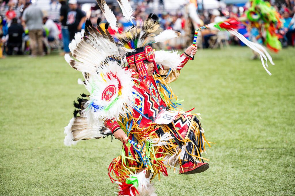 Young male fancy dancer in vibrant regalia performs at the Alabama-Coushatta 56th Annual Powwow, Livingston, Texas, June 2026.