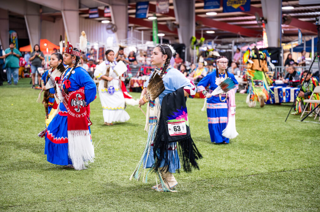 Native American women in traditional regalia dance at the Alabama-Coushatta 56th Annual Powwow in Texas, June 2025.