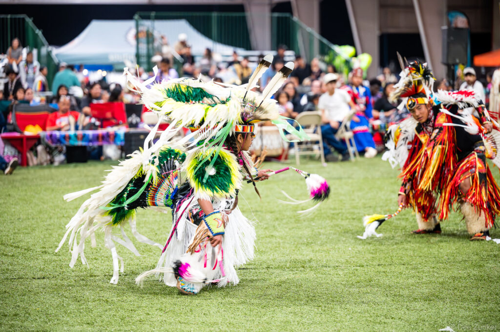 Two Native American dancers in elaborate regalia perform at the Alabama-Coushatta 56th Annual Powwow, Texas, June 2025.