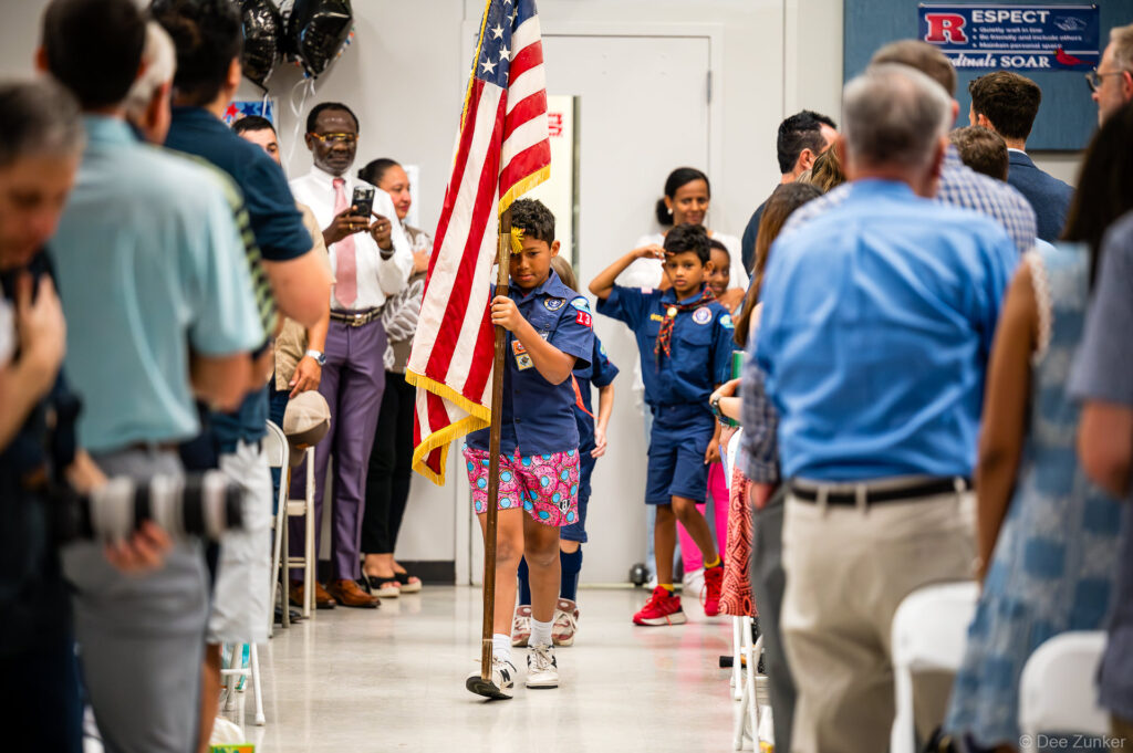 Cub Scout carries US flag down aisle at Horn Elementary 5th grade graduation ceremony in Bellaire TX